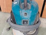 un aspirateur bleu et noir posé par terre