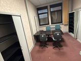 une pièce avec un bureau, des chaises et une bibliothèque