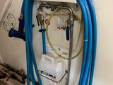 un tuyau bleu fixé au mur à côté d'un chauffe-eau