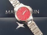 silver watch with red face on a blue box with a star on it