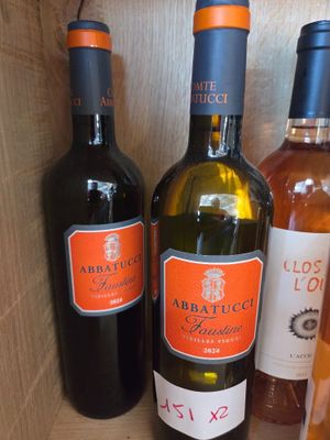several bottles of wine are lined up on a wooden shelf