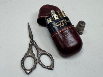 une paire de ciseaux et un étui en cuir posés sur une table