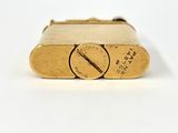 an image of a close up of a gold lighter on a white surface
