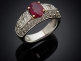 an oval ruby and diamond ring on a black surface
