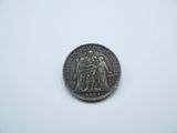 a silver coin with an image of a group of people on it