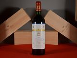 a bottle of wine sitting on a table next to wooden boxes