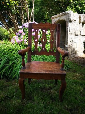 a wooden chair that is sitting in the grass