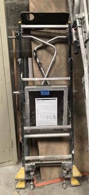 a ladder that is next to a wall with a sign on it