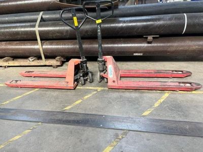 a forklift that is sitting in front of a pile of pipes