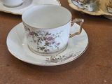 a cup and saucer sitting on a table next to a plate