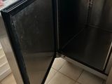 a small refrigerator that is open in the kitchen