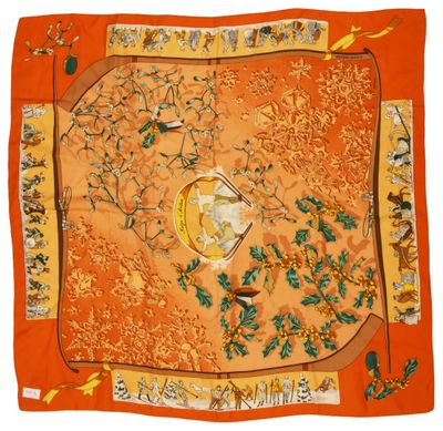 un foulard en soie orange orné d'oiseaux et de fleurs