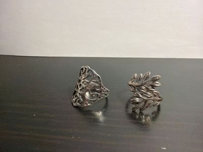 pair of silver plated earrings with leaves on them on a table