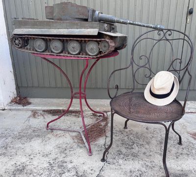 un chapeau posé sur une chaise à côté d'une table sur laquelle se trouve un bocal