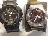 two watches that are sitting next to each other on a table