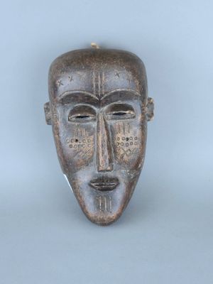 une image d'un masque en bois sur fond blanc
