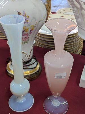 many vases and plates on the table with a red table cloth