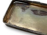 a metal tray with a handle on a white surface