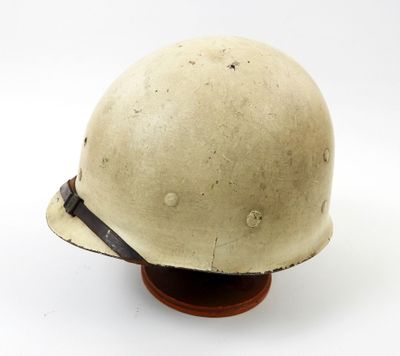 un gros plan d'un casque posé sur un socle en bois, sur fond blanc
