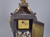a clock that is sitting on a stand with a door open