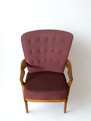 une image représentant une chaise rouge devant un mur blanc
