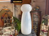 a white vase sitting on top of a table in a room