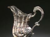 un pichet ancien en argent sur fond noir, avec un fond noir