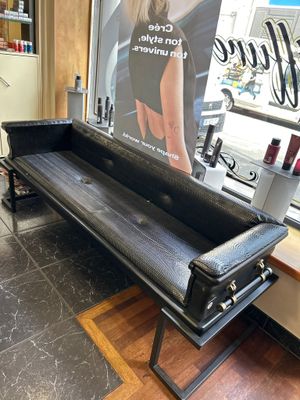 un banc noir placé devant une affiche accrochée au mur