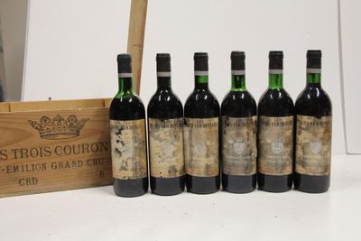 six bottles of wine are lined up in a row next to a wooden box