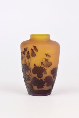 un vase jaune orné de fleurs noires sur un fond blanc