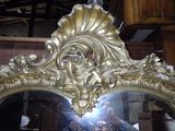 a mirror with a gold frame and a mirror with a face on it