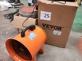 un souffleur orange posé par terre à côté d'une boîte