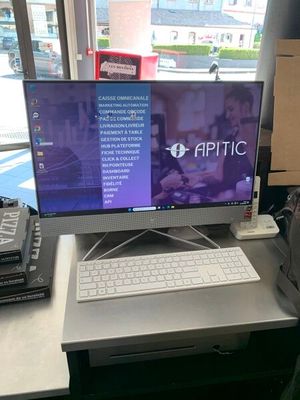 un écran d'ordinateur posé sur un bureau devant une fenêtre