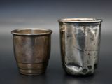 deux tasses en argent posées l'une à côté de l'autre sur une table
