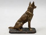 a statue of a dog sitting on top of a wooden base