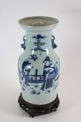 un vase bleu et blanc posé sur un socle, sur une surface blanche