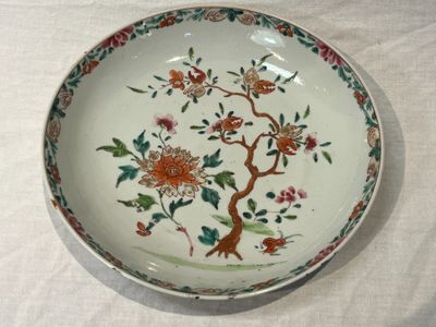 une assiette décorée de fleurs et d'oiseaux, posée sur une table