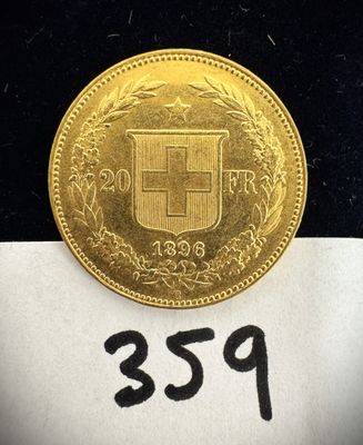 un gros plan d'une pièce d'or posée sur une feuille de papier blanc