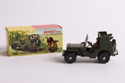 toy army jeep and box of dinky toys on a white surface