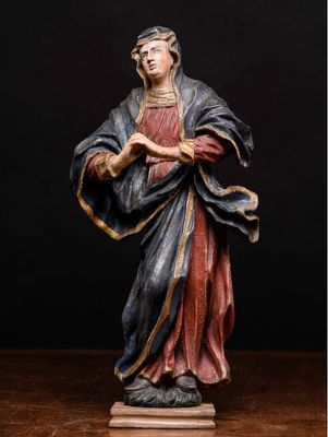une statue représentant une femme en robe rouge tenant un livre