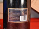 a bottle of wine sitting on a table next to a bottle of wine