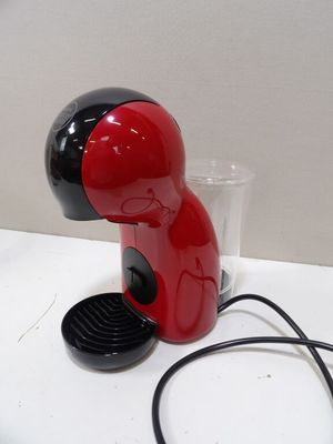 a red and black coffee maker on a white table