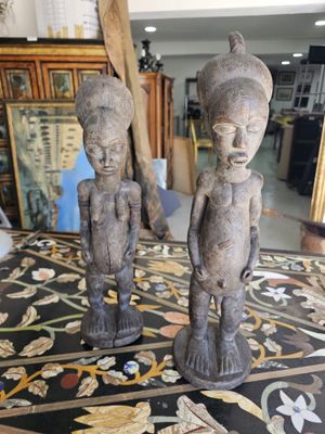two statues that are on a table in a room