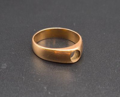 a close up of a gold ring on a black surface