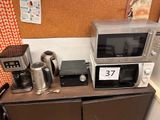 two microwaves and a coffee maker on the counter