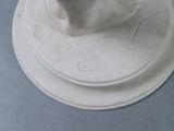 a figurine of a cat sitting on top of a white base
