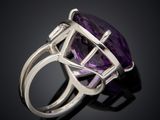 an amethorate and diamond ring on a black surface