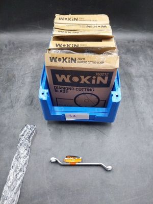 Deux boîtes de Wokin sont posées sur une table, à côté d'une clé à molette.