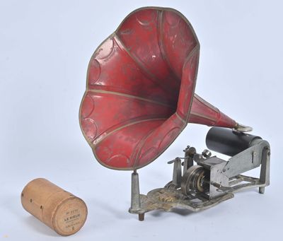 un gramophone rouge et argent à côté d'un bouchon en liège
