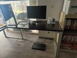 a desk with a computer monitor and a printer on it
